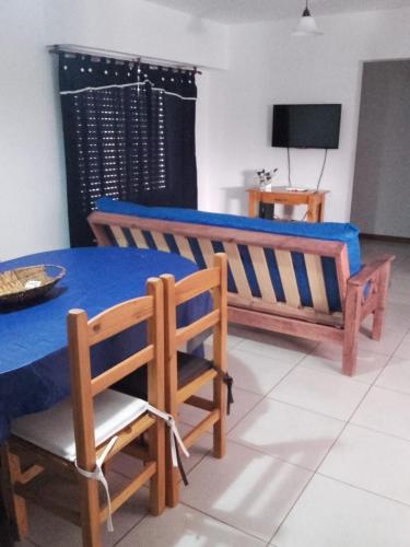 Un comedor con una mesa y sillas azules. en Ayres Pampeanos, en Santa Rosa
