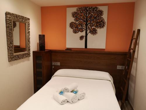 a room with a bed with three rolls of toilet paper at Albergue Restaurante Casa Herminia in El Campiello