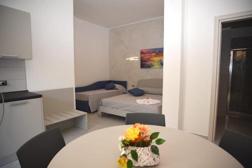 a room with a table with flowers on it at Angelo Bianco Appartment in Porto Cesareo