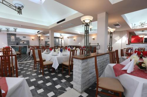 a dining room with white tables and chairs at Hotel Doina in Neptun