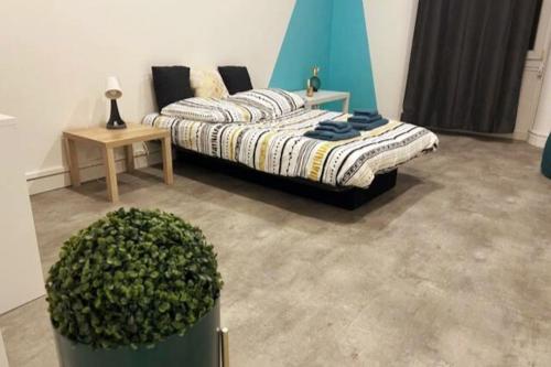 um quarto com uma cama, uma mesa e uma planta em Label Etape - 2min GARE - WIFI - TeRRaSSe em Marselha