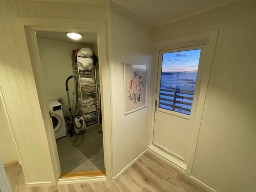 um quarto vazio com uma porta e uma janela em Å, the far end of Lofoten, top apartment. em Sorvagen