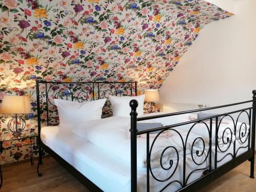 a bedroom with a bed with a floral wallpaper at Pension Pfefferstübchen in Brotterode-Trusetal