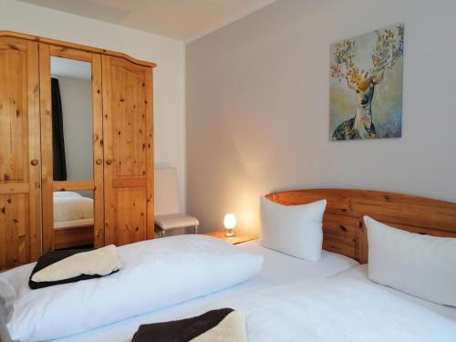a bedroom with two beds and a mirror at Pension Pfefferstübchen in Brotterode-Trusetal
