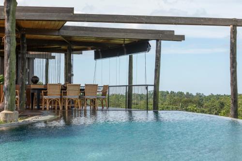 a swimming pool with a table and chairs in the water at Trebartha East The Round House in Ahangama