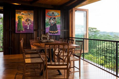 a dining room with a table and chairs on a balcony at Trebartha East The Round House in Ahangama