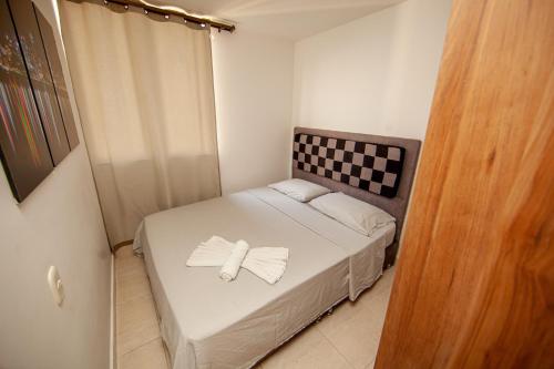 a small bedroom with a bed with a bow on it at Apartamentos en el Sur de Cali, parqueadero propio, piscina, wifi in Cali