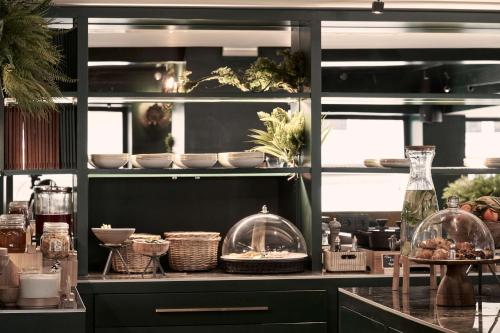 a kitchen with a counter with food and dishes on it at The Social Athens Hotel, a member of Radisson Individuals in Athens