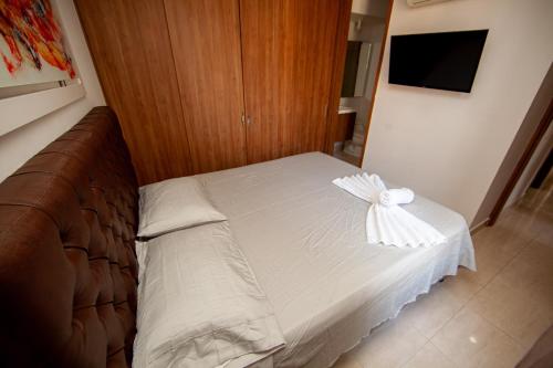 a bed with a white bow on it in a room at Apartamentos en el Sur de Cali, parqueadero propio, piscina, wifi in Cali