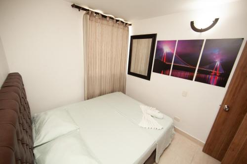 a bedroom with a bed and a picture on the wall at Apartamentos en el Sur de Cali, parqueadero propio, piscina, wifi in Cali