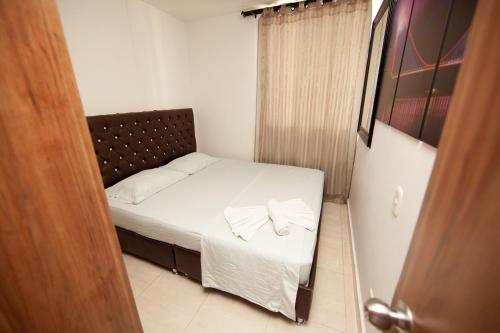 a small bed in a small room with a door at Apartamentos en el Sur de Cali, parqueadero propio, piscina, wifi in Cali