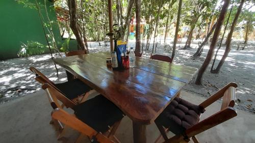 una mesa de madera con sillas y botellas de cerveza. en Chalés Guigó-Cumuruxatiba, en Cumuruxatiba