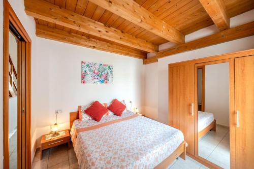 1 dormitorio con cama y techo de madera en Casa Vacanza sotto torre, en Calasetta