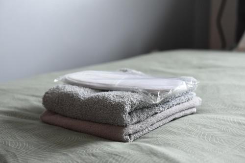 una pila de toallas sentadas encima de una cama en Siena en Novi Sad