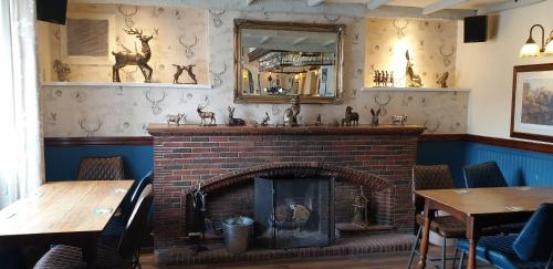 una chimenea en un restaurante con un espejo en la pared en George Washington Inn en Carnforth