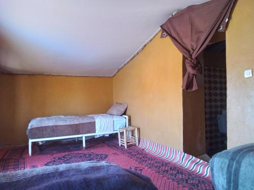 a room with two beds and a rug at Mhamid Regency Camp in Mhamid