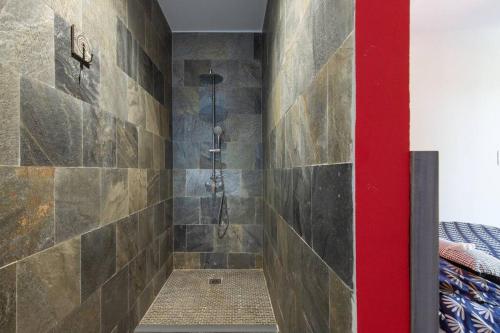 a bathroom with a shower with a stone wall at Villa Benjoin St-Pierre Piscine chauffée et mer in Saint-Pierre