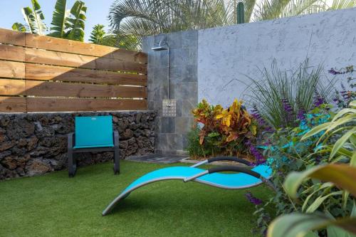 a garden with a bench and a blue laptop at Villa Benjoin St-Pierre Piscine chauffée et mer in Saint-Pierre