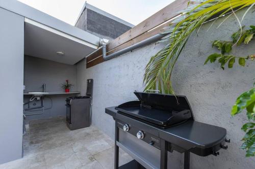 a kitchen with a black stove and a sink at Villa Benjoin St-Pierre Piscine chauffée et mer in Saint-Pierre
