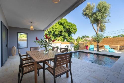 a dining room with a table and chairs and a pool at Villa Benjoin St-Pierre Piscine chauffée et mer in Saint-Pierre