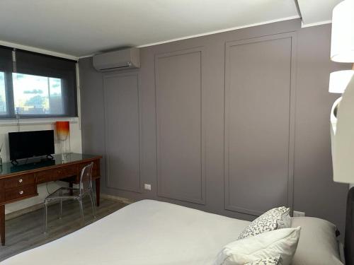 a bedroom with a bed and a desk and a television at Attico al Mare in Lido di Ostia