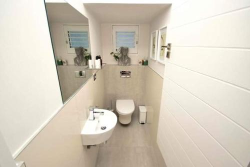 La salle de bains blanche est pourvue d'un lavabo et de toilettes. dans l'établissement Andrew's property two, à Vosburg