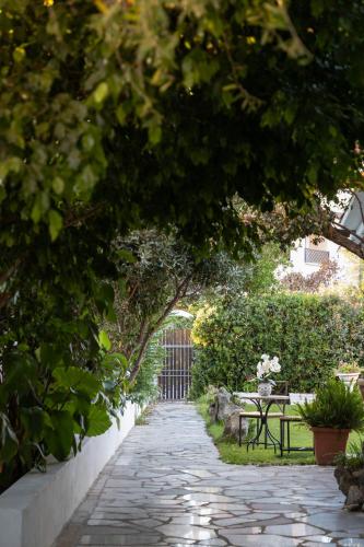 a garden path with a table and a bench at Casa Perdas - Gate to the Sea by Homey Experience in Olbia