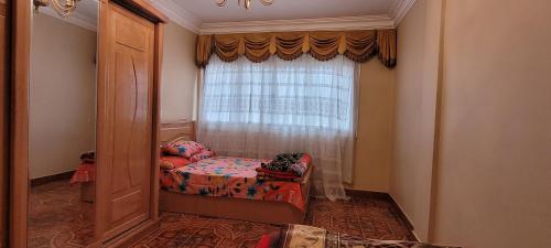 a small bedroom with a bed and a window at Cozy 3BR Place Nasr City in Cairo