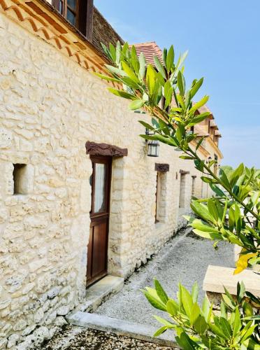 a stone building with a wooden door on a street at Le Domaine de Camberoux gite in Bressac