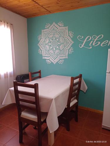 una mesa y sillas en una habitación con una pared en LIBERATA en Esquel