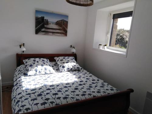 a bedroom with a bed with a black and white comforter at gite des Korrigans in Kerimel