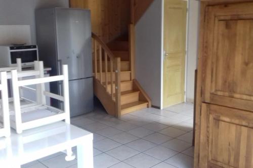 a kitchen with a refrigerator and stairs in a room at gite des Korrigans in Kerimel