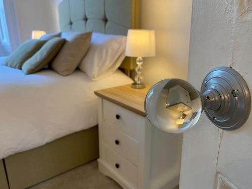 a bedroom with a bed and a table with a lamp at Regency Apartment in the heart of Leamington Spa in Leamington Spa