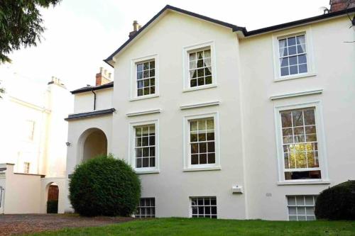 een wit huis met ramen en een tuin bij Regency Apartment in Leamington Spa