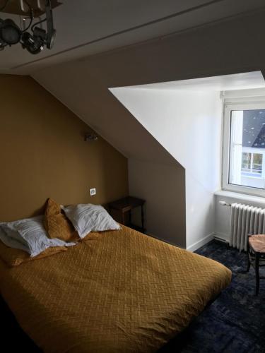 a bedroom with a large bed in a attic at Auberge Du Camfrout in Hôpital-Camfrout