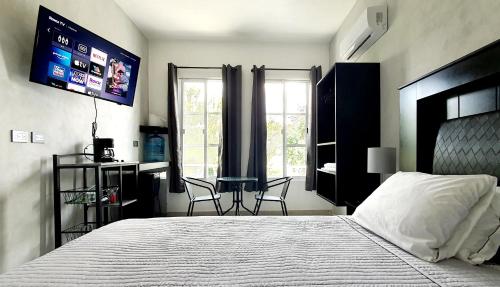 1 dormitorio con cama, mesa y TV en Cozumel 400A - Vacation Rental, en Cozumel