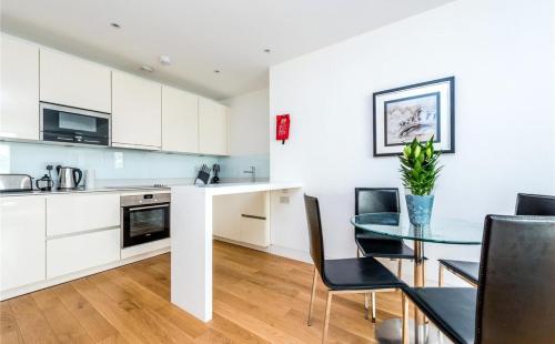 a kitchen and dining room with a glass table and chairs at Luxury Holiday Let @ London City in London