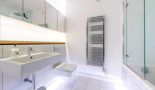 a white bathroom with a sink and a shower at Luxury Holiday Let @ London City in London