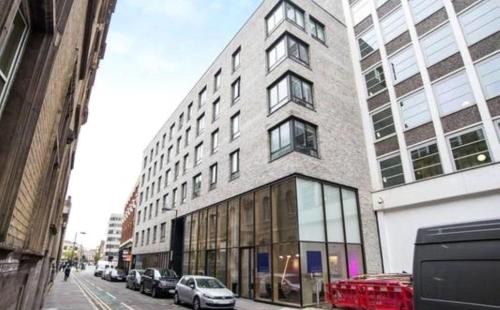 a tall building with cars parked in front of it at Luxury Holiday Let @ London City in London