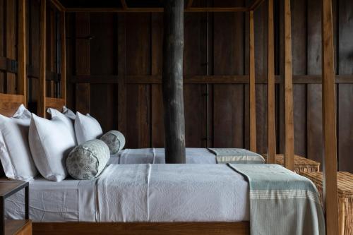 a bedroom with a bed with white sheets and pillows at Trebartha East The Round House in Ahangama