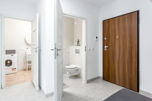 bagno con servizi igienici e porta in legno di Chill Apartments Marywilska II a Varsavia