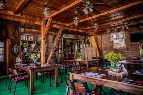 une salle à manger avec des plafonds en bois, des tables et des chaises dans l'établissement Oławian Hotel, à Oława