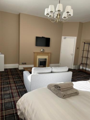 a living room with two beds and a tv at Carlton House Guesthouse in Scarborough