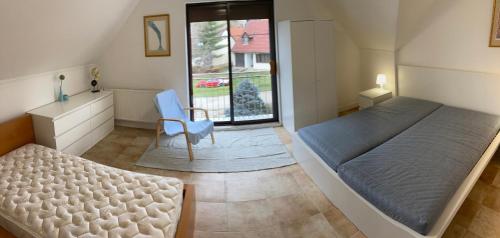 um quarto com uma cama, uma cadeira e uma secretária em Amerikai Álom em Orfű
