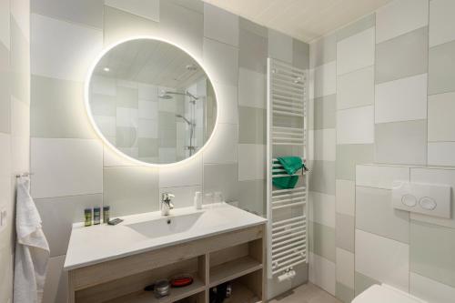 a bathroom with a sink and a mirror at Hotel De Vossemeren by Center Parcs in Lommel