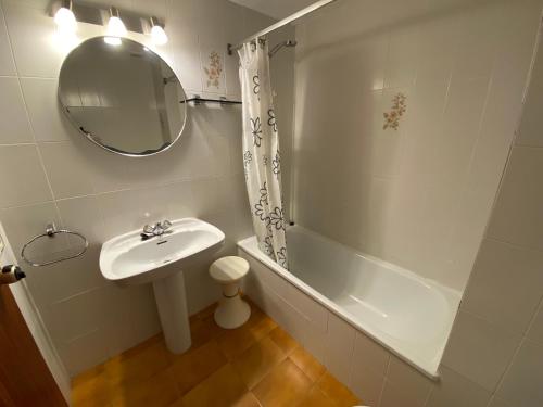 a bathroom with a sink and a tub and a mirror at Mar Play in Sant Antoni de Calonge