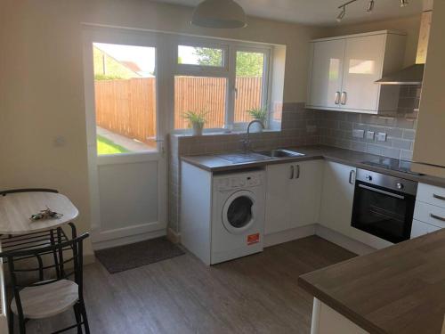 a kitchen with a washing machine and a sink at Delightful 2 bedroom house between Bristol & Bath in Warmley