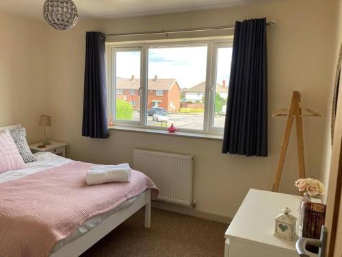 a bedroom with a bed and a large window at Delightful 2 bedroom house between Bristol & Bath in Warmley