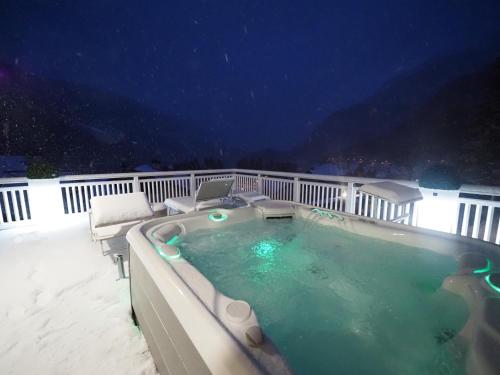 a hot tub on the deck of a house at Hotel Europa in Molveno