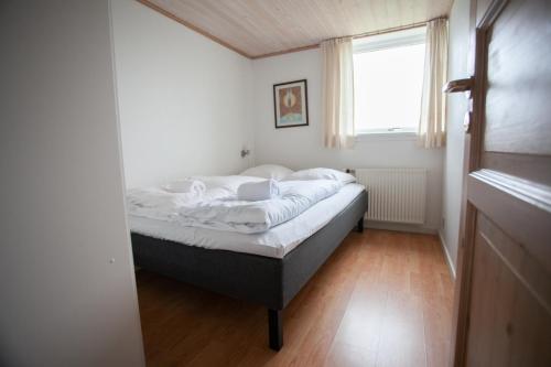Un dormitorio con una cama en una habitación con ventana. en 2BR Apt / Central / Tórshavn, en Tórshavn